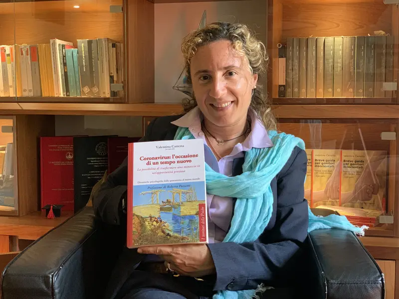 Dott.ssa Valentina Carretta, psicologa psicoterapeuta psicoanalista di Cernusco sul Naviglio con in mano il libro Coronavirus: l’occasione di un tempo nuovo