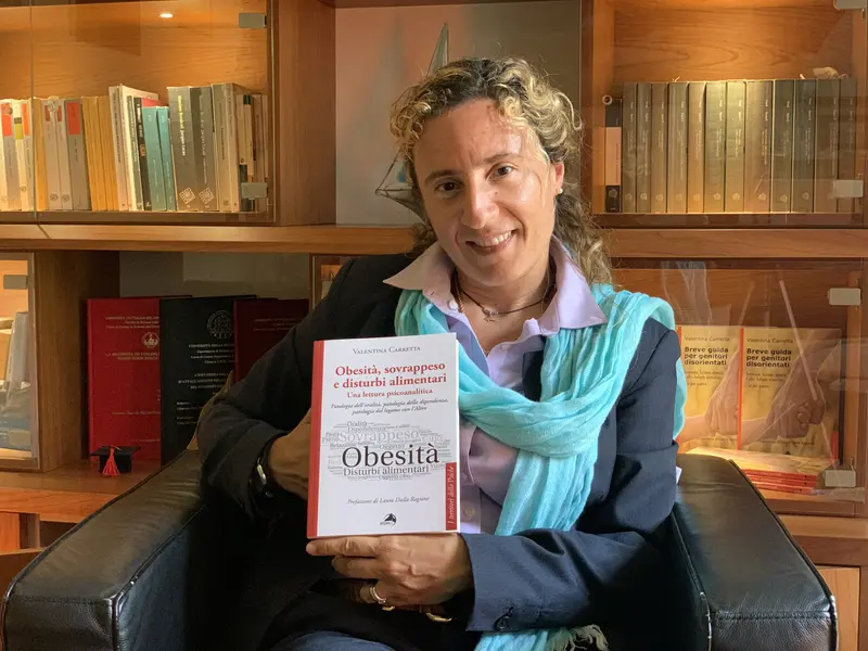 Dott.ssa Valentina Carretta, psicologa psicoterapeuta psicoanalista di Cernusco sul Naviglio con in mano il libro Obesità, sovrappeso e disturbi alimentari: una lettura psicoanalitica.